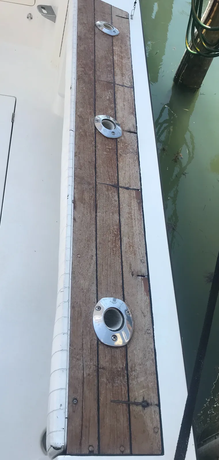 Weathered covering board section on a sportfishing boat before replacement